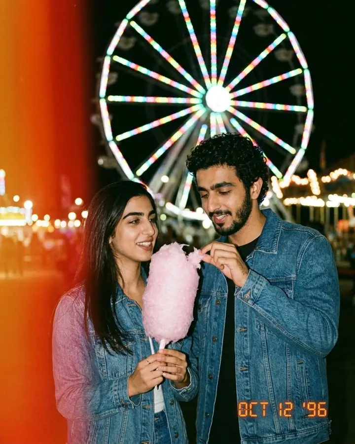 AI example of a 90s film snapshot of a couple sharing candy floss at a fairground